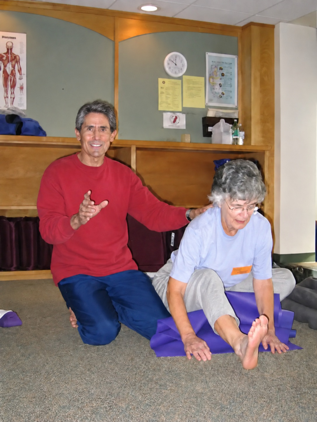 Sam Dworkis guiding a student during a yoga workshop